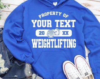 May include: Royal blue hoodie with white text that reads "Property of Your Text 20 XX Weightlifting".