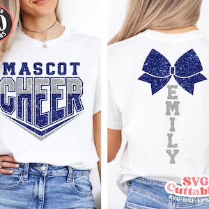 Puede incluir: Dos camisetas blancas con un diseño de purpurina azul y plateada. Una camiseta dice "Mascot Cheer" y la otra tiene un lazo azul de purpurina y el nombre "Emily" escrito verticalmente.