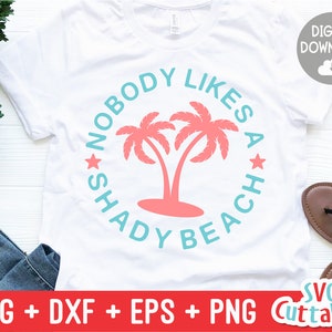 May include: A white t-shirt with a blue circle graphic that says "Nobody Likes a Shady Beach" with palm trees in the center. The palm trees are pink and the text is in a light blue color.