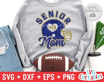 May include: A gray sweatshirt with the text "Senior Mom" in gold glitter letters. A blue and gold glitter football helmet with a heart and the number 19 is above the text.