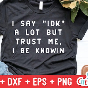 May include: Black t-shirt with white text that reads "I say "IDK" a lot but trust me, I be knowin".