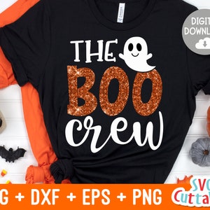 May include: Black t-shirt with the text "The Boo Crew" in white lettering. The word "Boo" is in orange glitter. A white ghost with a smiling face is above the text.