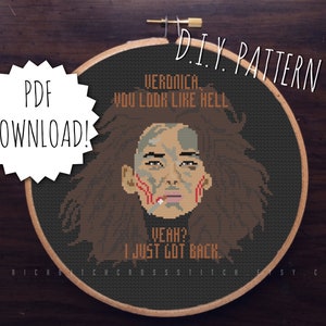 May include: A cross-stitch pattern in a wooden hoop. The design features a pixelated portrait with the text "VERONICA, YOU LOOK LIKE HELL. YEAH? I JUST GOT BACK." The words "PDF DOWNLOAD!" and "D.I.Y. PATTERN" are also visible.