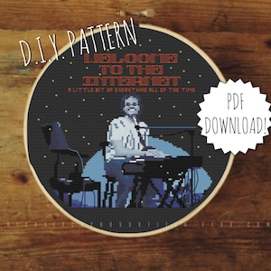 May include: A black and white cross-stitch pattern of a person playing a keyboard with the text "Welcome to the Internet. A little bit of everything all of the time." The pattern is in a round hoop and has a "PDF Download!" label.