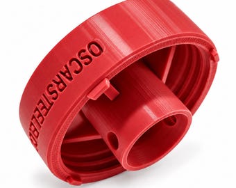 May include: A bright red, circular plastic cap featuring a central cylindrical protrusion with two small circular openings. The outer rim is embossed with the text OSCARSTEEL and includes internal threading and small locking tabs.