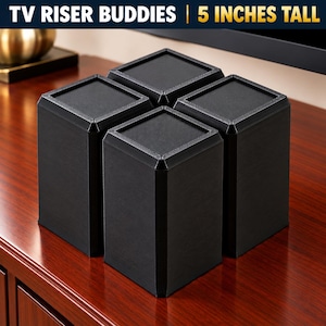 May include: A set of four black rectangular TV Riser Buddies, each measuring 5 inches tall. These solid, upright supports feature a textured top surface and a smooth, matte finish on the sides, designed to elevate electronic equipment.