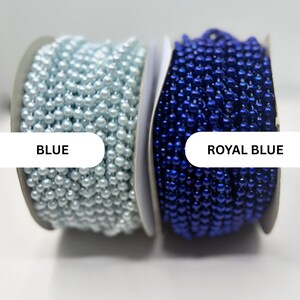 May include: Two spools of beaded chain trim. The left spool features light blue beads, labeled BLUE. The right spool features deep royal blue beads, labeled ROYAL BLUE. Both spools are wound with continuous strands of small, round, glossy beads.