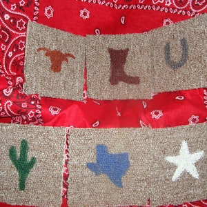 Puede incluir: Seis cuadrados de alfombra beige con diferentes diseños bordados. Los diseños incluyen un toro longhorn, una bota de vaquero, una herradura, un cactus, una estrella azul y una estrella blanca.