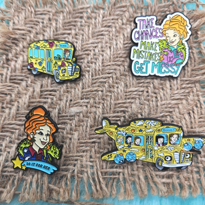 May include: Four enamel pins featuring characters and a school bus from the Magic School Bus series. The pins are yellow, blue, green, and red. The text on the pins reads "Take Chances Make Mistakes Get Messy", "Zoom!" and "Do It For Her".