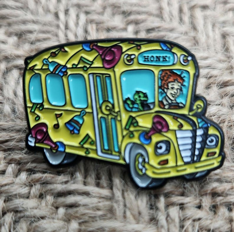 May include: A yellow school bus with a black outline and a red, white, and blue musical design. The bus has a sign that says "HONK!" and a driver with red hair and a green creature in the passenger seat.
