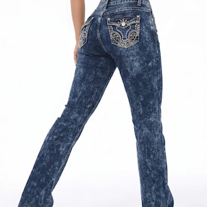 May include: Dark blue acid-wash denim jeans featuring a high-waisted fit and straight-leg cut. The back pockets are embellished with intricate gold-tone embroidery, metallic studs, and small clear rhinestones in a decorative swirling pattern.
