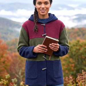 May include: A color-blocked hooded jacket featuring horizontal panels of burgundy, olive green, and navy blue wool-like fabric. The jacket includes a front closure with three silver-toned toggle fasteners and two large patch pockets on the front.