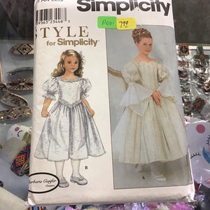 May include: Simplicity pattern #9363 for a girl's dress. The pattern includes two styles: a dress with puffed sleeves and a dress with long, flowing sleeves. The pattern is titled "TYLE for Simplicity".