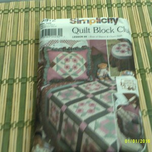 Pode incluir: Um livreto de padrões Simplicity Quilt Block Club com um design de colcha rosa e verde. O livreto é intitulado "Quilt Block Club" e inclui o texto "Lesson #4: Rose of Sharon & Cherry Cake".