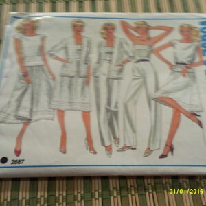 May include: A vintage sewing pattern for women's clothing. The pattern includes four different styles: a skirt and top, a jacket and skirt, a pantsuit, and a dress. The pattern is for size 2587.
