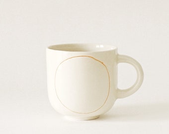 Handmade Ceramic mug with orange circle H: 3″