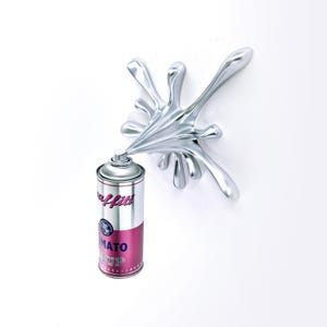May include: A silver-colored sculpture of a spray paint can with a splash design. The can is silver and red with the word "Graffiti" and "Tomato Soup" printed on it. The splash is a shiny, fluid shape.