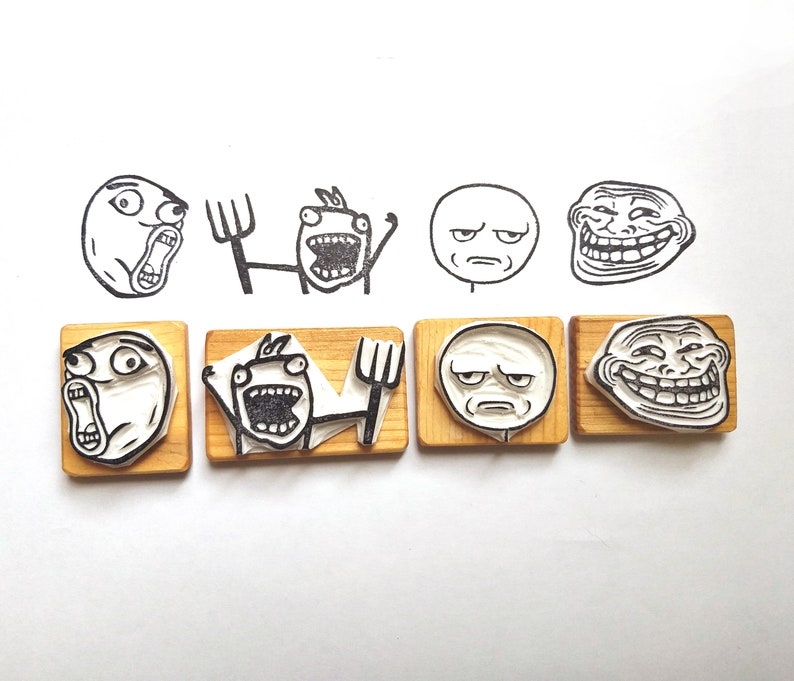 May include: Set of six wooden stamps featuring various internet meme faces, including troll face, forever alone, and rage guy. The stamps are on a white background.