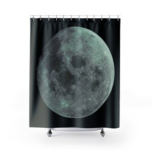 May include: A black shower curtain with a large, detailed image of a green moon.