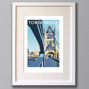 May include: A framed print of a colorful illustration of Tower Bridge in London, England. The print features a blue sky, a white moon, and the text "TOWER BRIDGE" in blue letters.