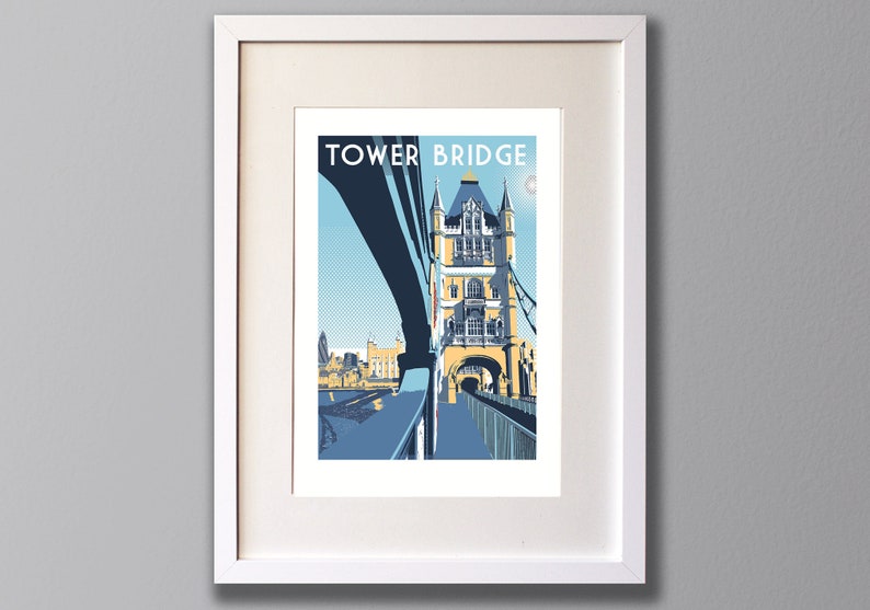 May include: A framed print of a colorful illustration of Tower Bridge in London, England. The print features a blue sky, a white moon, and the text "TOWER BRIDGE" in blue letters.