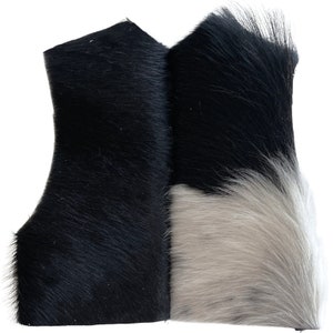May include: A black and white cowhide rug with a long, soft pile. The rug is made of natural cowhide and has a unique, natural pattern.