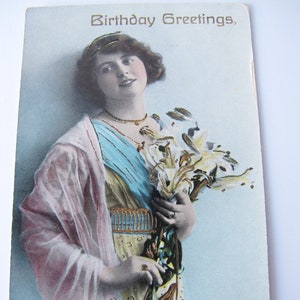 Antike fotografische Glückwunschkarte zum Geburtstag. Frau mit Lilienstrauß. Gold Details.