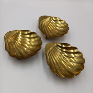 Vintage set med tre snäckformade fat på fot. Guldfärgad metall.
