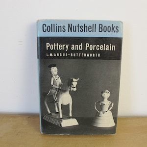 May include: A vintage book titled "Pottery and Porcelain" by L.M. Angus-Butterworth, part of the Collins Nutshell Books series. The cover features a black and white illustration of a porcelain figurine of a man riding a horse and a porcelain figurine of a woman in a dress.