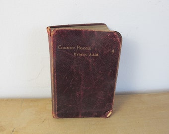 Libro antiguo de oración común, con himnos antiguos y modernos. Pequeño libro de bolsillo, con cubierta de cuero rojo oscuro y páginas con bordes dorados.