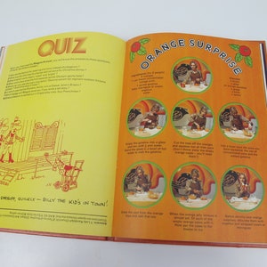 May include: Open book with a yellow page featuring a quiz and a cartoon illustration. The opposite page has an orange-themed recipe titled "Orange Surprise" with step-by-step photos and instructions.