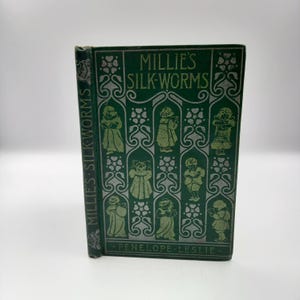 May include: A vintage green book titled "Millie's Silk-Worms" by Penelope Leslie. The cover features a repeating pattern of stylized flowers and children in green and silver.