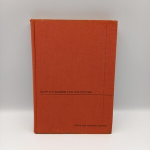 May include: An orange book with the title "Clay and Glazes for the Potter" and the text "Arts and Crafts Series" on the cover.