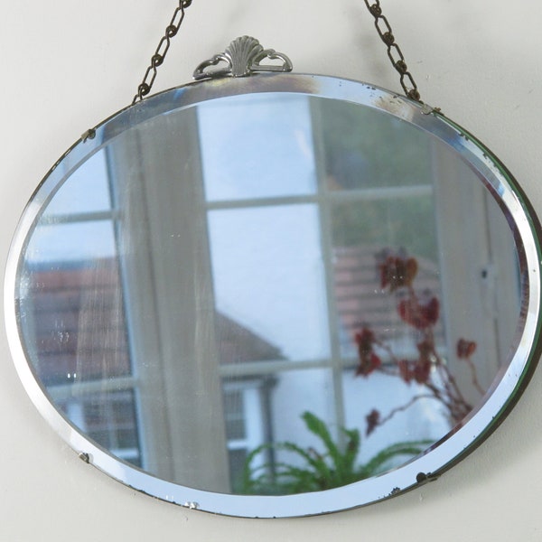 Oval Art Deco Mirror. Frameless with bevelled edge, original visible chain and metal detail. 1936