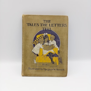 Op de afbeelding: Een vintage boek getiteld "The Tales The Letters Tell" met een gele en blauwe illustratie van drie kinderen die een boek lezen. Het boek is gelabeld "Book I" en "Illustrated by Margaret W. Tarrant".