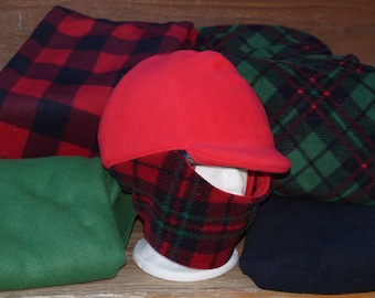 Puede incluir: Un gorro de lana roja con una máscara facial de cuadros negros y rojos. El gorro tiene una visera y está doblado sobre las orejas. La máscara está hecha de un material de lana suave y cálido. El gorro y la máscara están hechos de un material de lana suave y cálido.