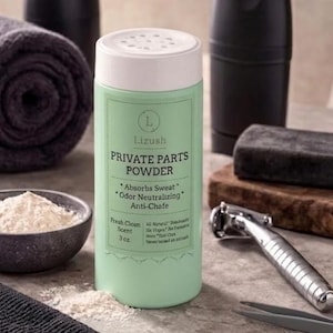 May include: A light green bottle of "Private Parts Powder" with a white lid, next to a bowl of powder, a rolled-up towel, and shaving accessories. The bottle's label says it absorbs sweat and neutralizes odor.