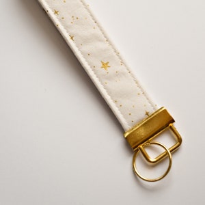 Llavero de pulsera con ESTRELLAS BLANCAS Y DORADAS de Rifle Paper Co.