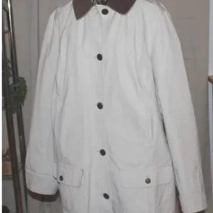 May include: A cream-colored jacket with a brown collar and black buttons. The jacket has two front pockets and is displayed on a mannequin. The jacket is a classic outerwear piece.