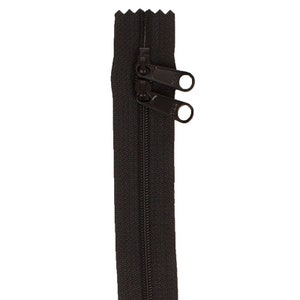 May include: A black zipper with two pull tabs. The zipper is closed and the pull tabs are at the top.
