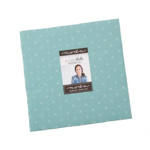 May include: A light blue fabric square with a white snowflake pattern. The fabric is from the Moda Bella Solids line by Moda Fabrics.