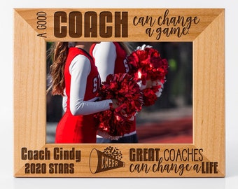 May include: A wooden picture frame with a photo of cheerleaders. The frame is engraved with the text "A good coach can change a game. Great coaches can change a life." and "Coach Cindy 2020 Stars".