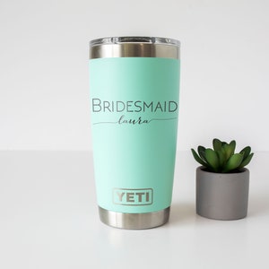 K&ouml;nnte beinhalten: Ein minzgr&uuml;ner Yeti-Becher mit dem Text "BRIDESMAID Laura" und dem Yeti-Logo.
