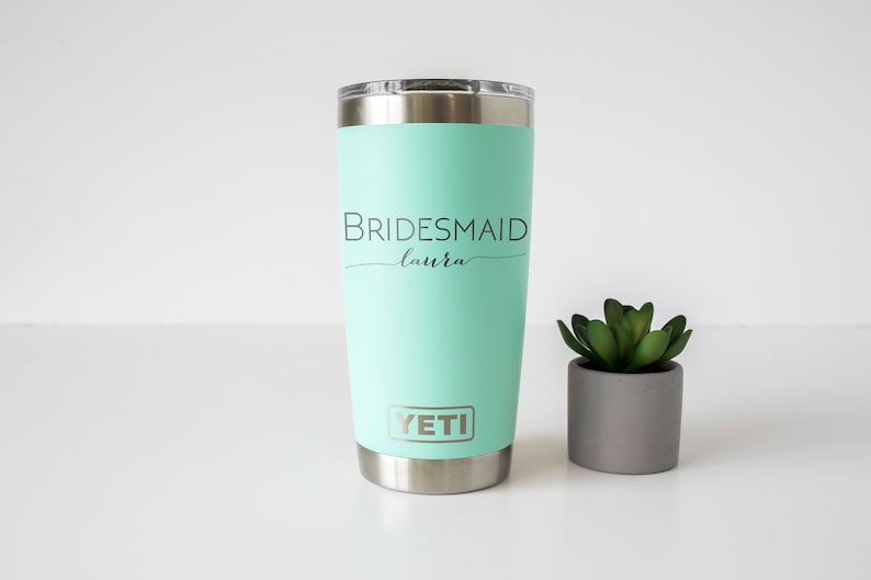 K&ouml;nnte beinhalten: Ein minzgr&uuml;ner Yeti-Becher mit dem Text "BRIDESMAID Laura" und dem Yeti-Logo.