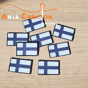 Peut inclure: Huit patchs thermocollants représentant le drapeau finlandais bleu et blanc sur une surface en bois. Les patchs mesurent environ 5 cm sur 7,5 cm.