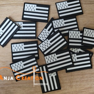Peut inclure: Plusieurs écussons brodés noirs et blancs représentant le drapeau breton. Les écussons rectangulaires présentent une bordure noire, des rayures blanches horizontales et un canton avec des hermines noires. Le logo "ANJA CREATION BRODERIE" est visible.