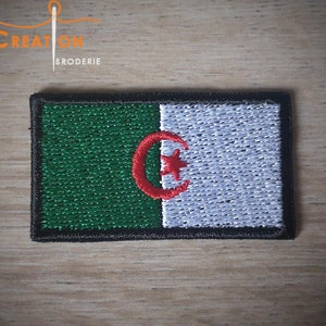 May include: An embroidered patch of the Algerian flag. The flag is green, white, and red with a crescent moon and star in the center.
