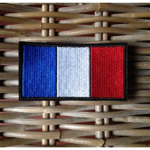 Peut inclure: Un patch brodé bleu, blanc et rouge avec une bordure noire, ressemblant au drapeau français.