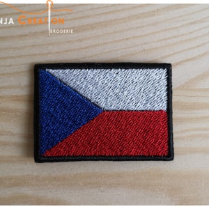 Puede incluir: Parche bordado de la bandera de la República Checa con un diseño blanco, azul y rojo. El parche tiene un borde negro.