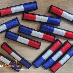 Peut inclure: Dix patchs brodés thermocollants représentant le drapeau français en rouge, blanc et bleu. Les patchs sont rectangulaires et ont une bordure noire.